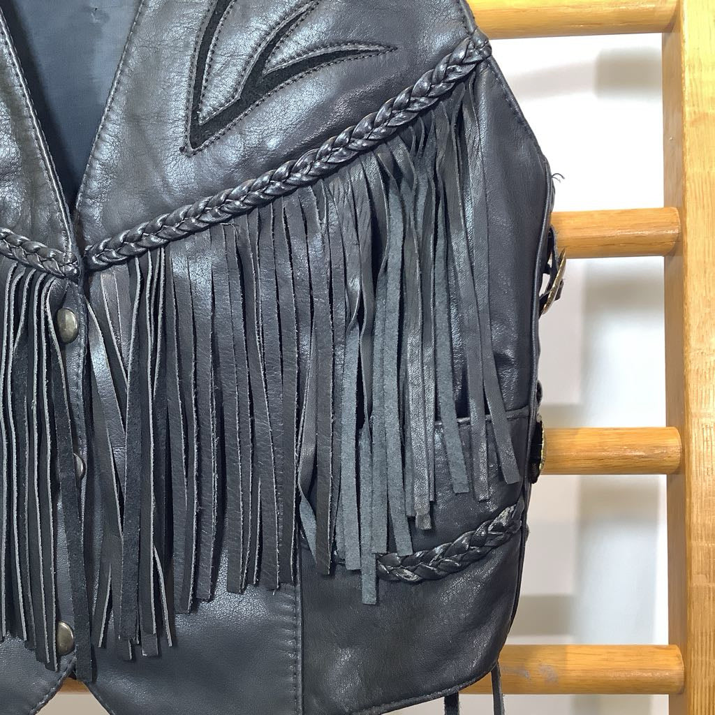 Black leather fringe jacket on a wooden chair