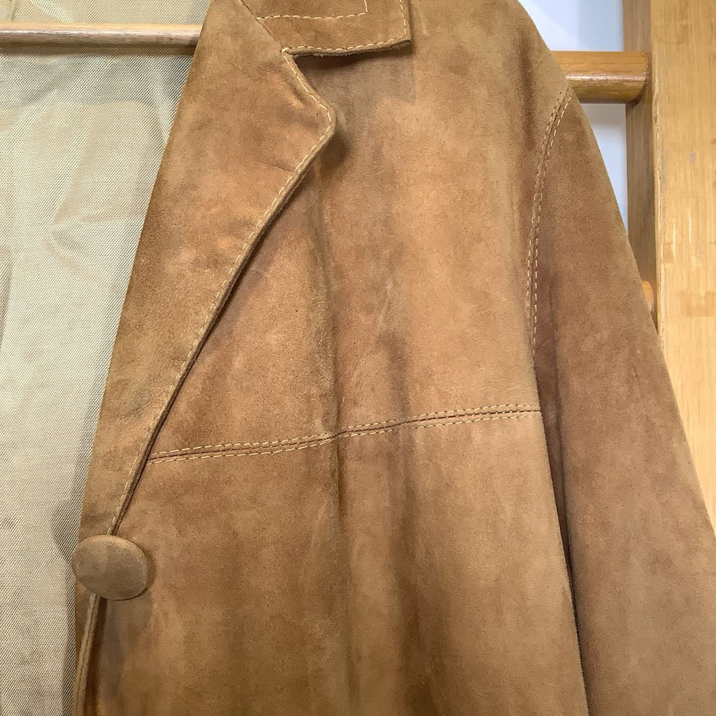 Brown leather jacket on a wooden stand with a neutral background