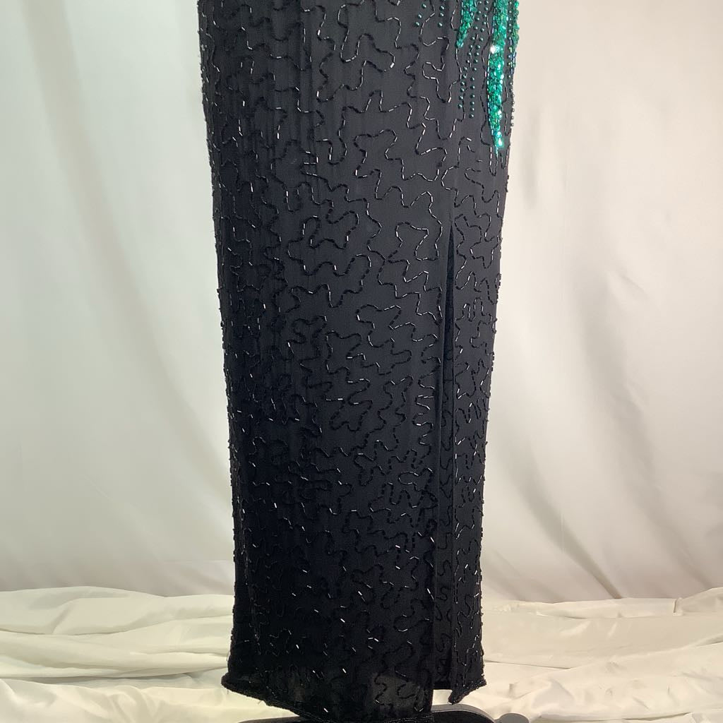 Black beaded dress with green accents on a white background