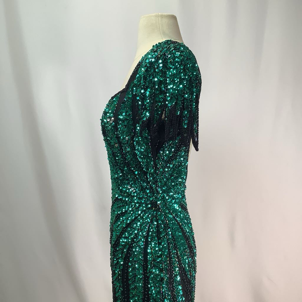 Green sequin dress on a mannequin against a plain background