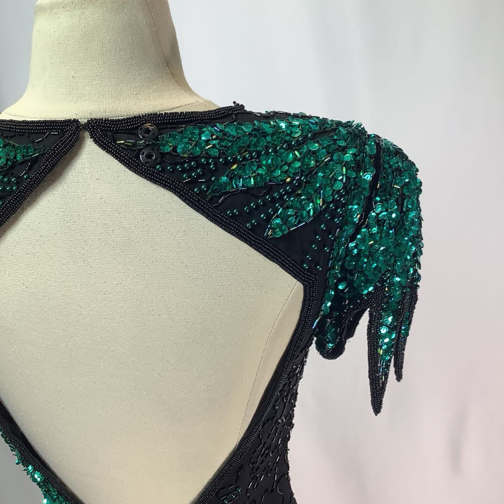 Green and black beaded shoulder piece on a mannequin