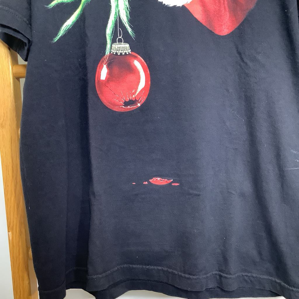 Black t-shirt with a red ornament graphic on a wooden chair.