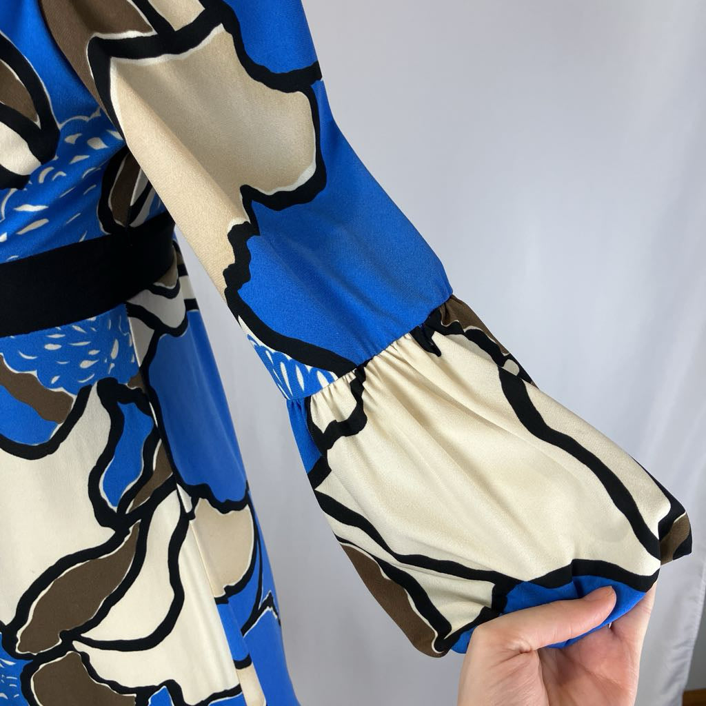 Close-up of a patterned fabric with blue, beige, and black design on a plain background