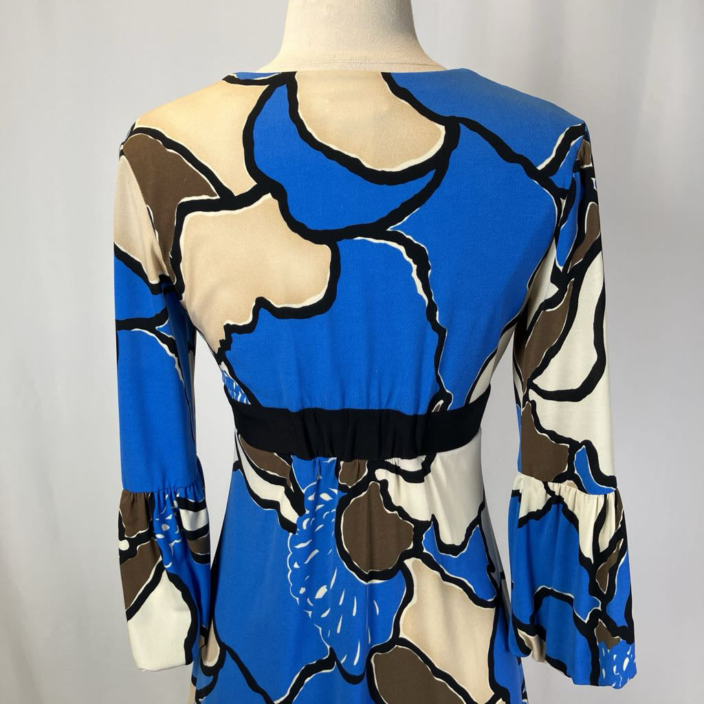 Mannequin wearing a blue, brown, and beige patterned dress against a plain background