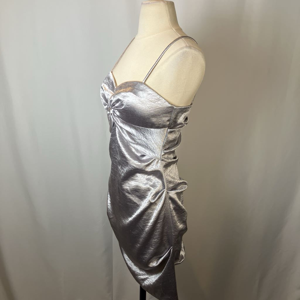 Silver metallic dress on a mannequin against a plain background