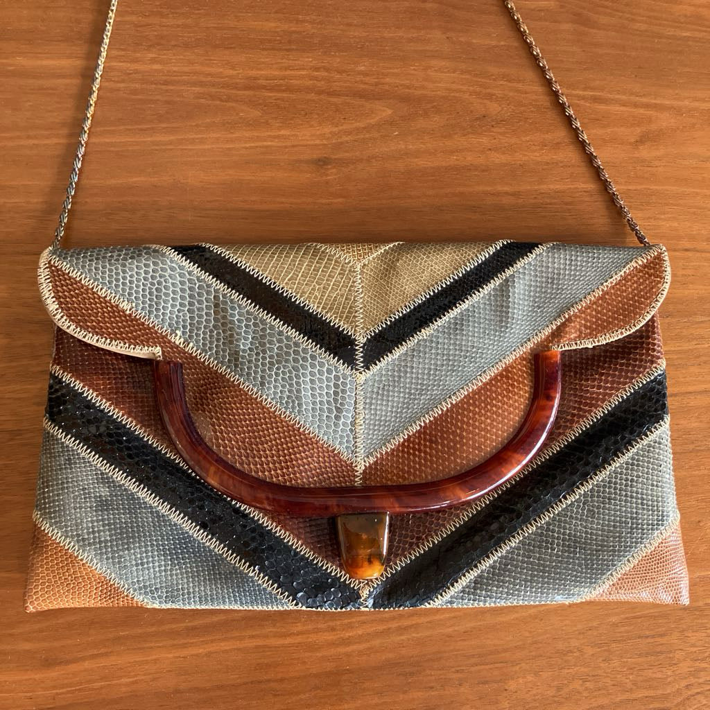 Snakeskin envelope bag on a wooden surface