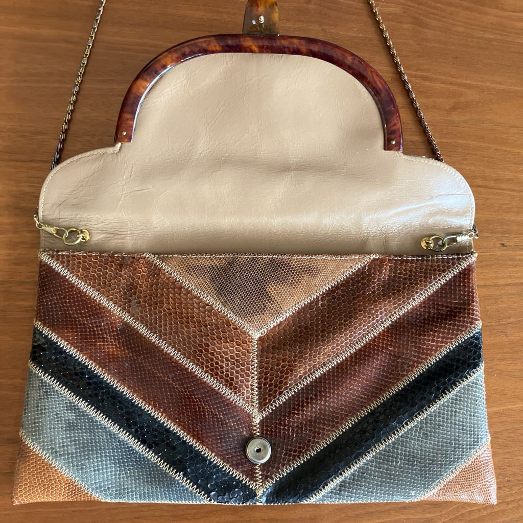 Snakeskin envelope bag on a wooden surface