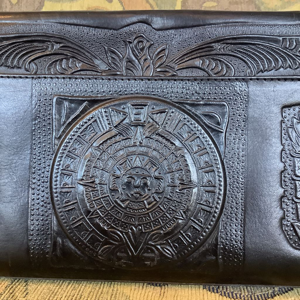 Black leather wallet with embossed design on a textured surface