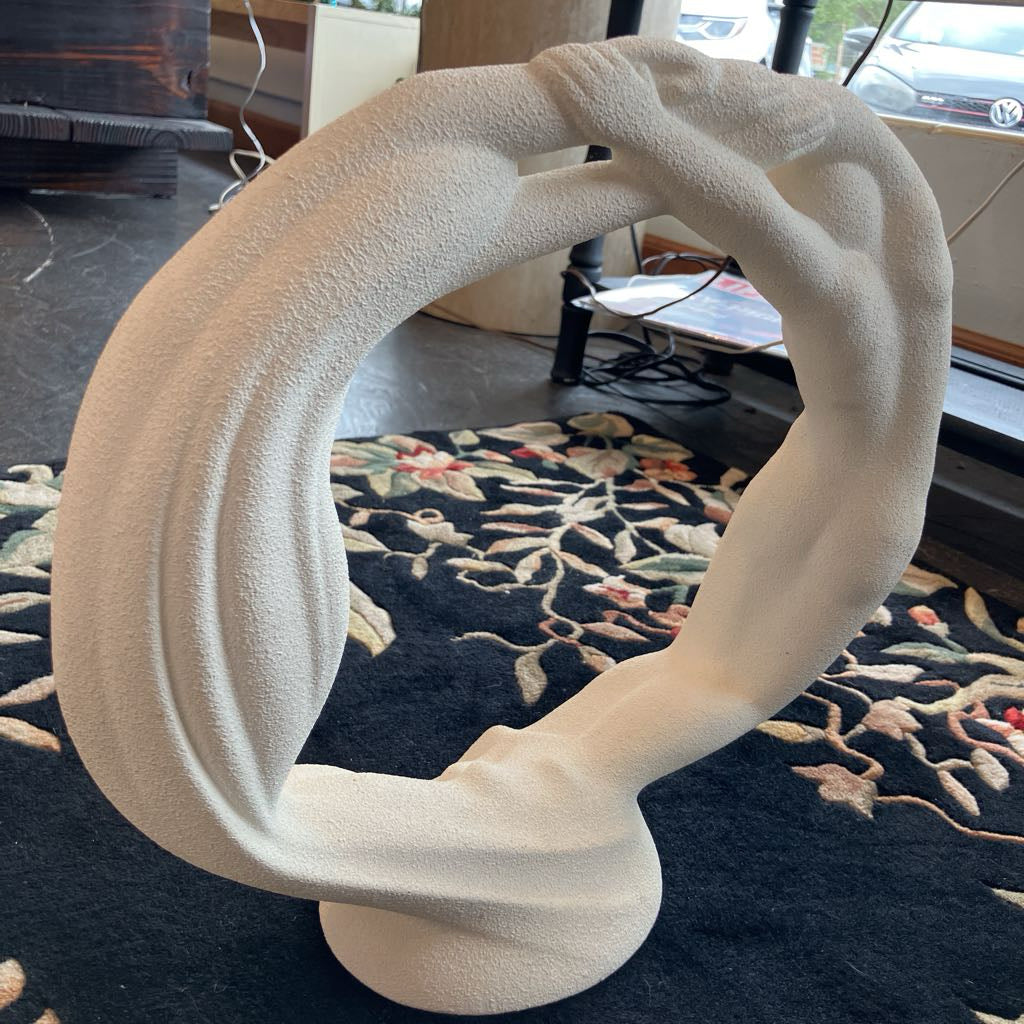 White abstract sculpture on a dark patterned rug