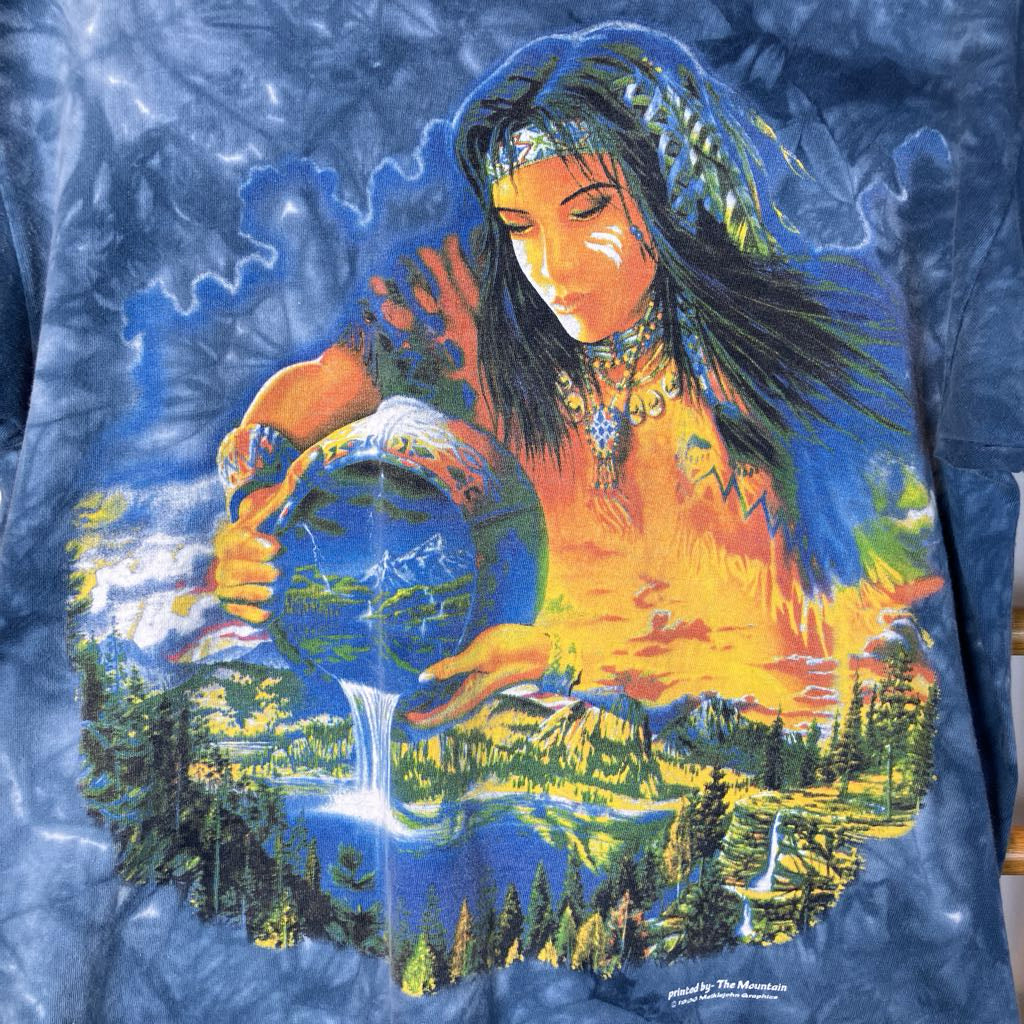 T-shirt with a colorful design of a woman holding a globe with nature elements on a blue tie-dye background.