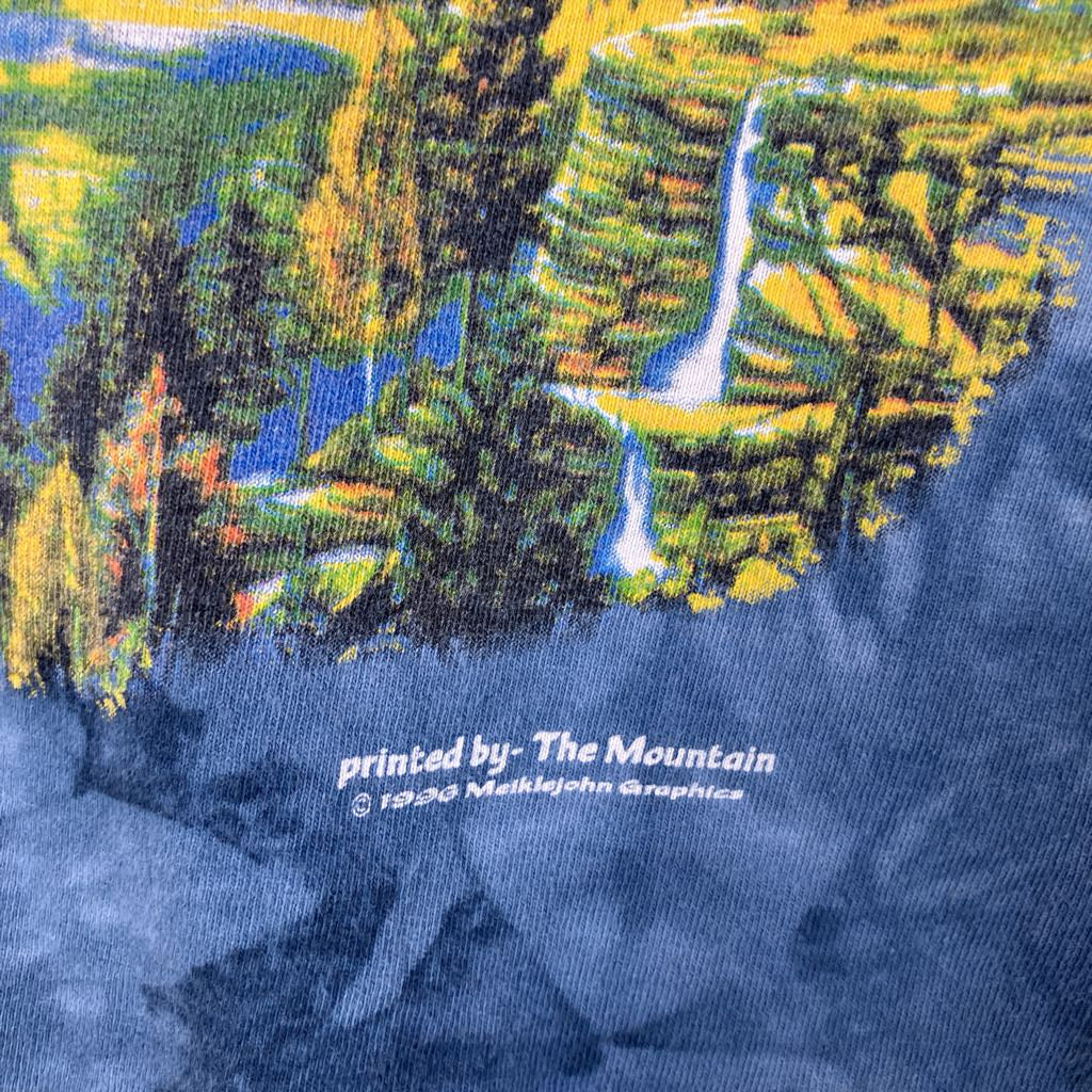 Close-up of a graphic t-shirt with a mountain and waterfall design, featuring 'The Mountain' print.