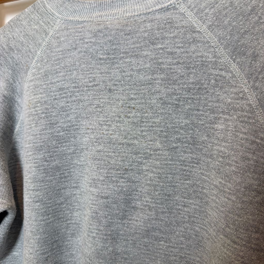 A gray sweatshirt on the front hanging on a wooden rack.