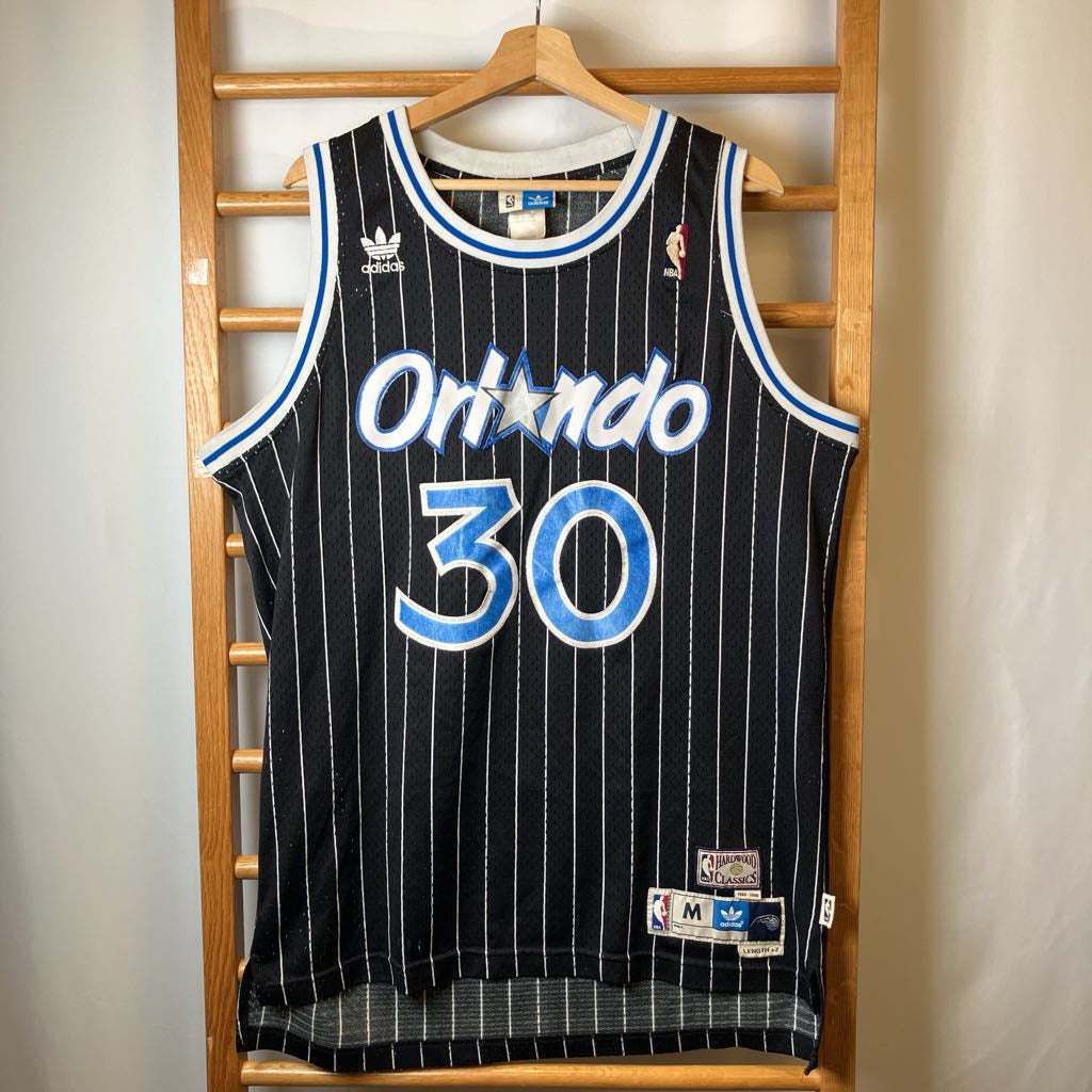 Basketball jersey with 'Orlando' and number '30' on a wooden rack.