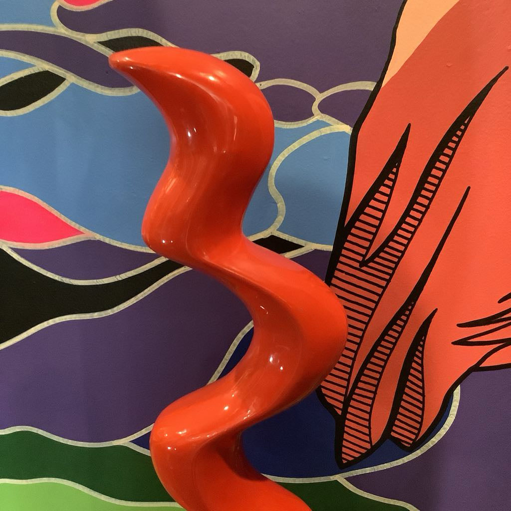 Abstract art with a red wavy line against a colorful background