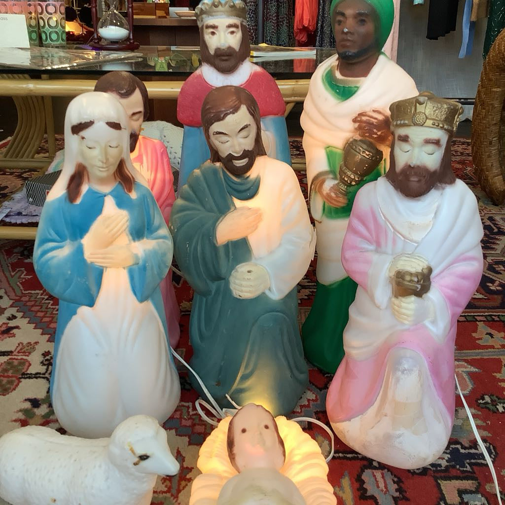 Decorative nativity scene figures on a patterned rug