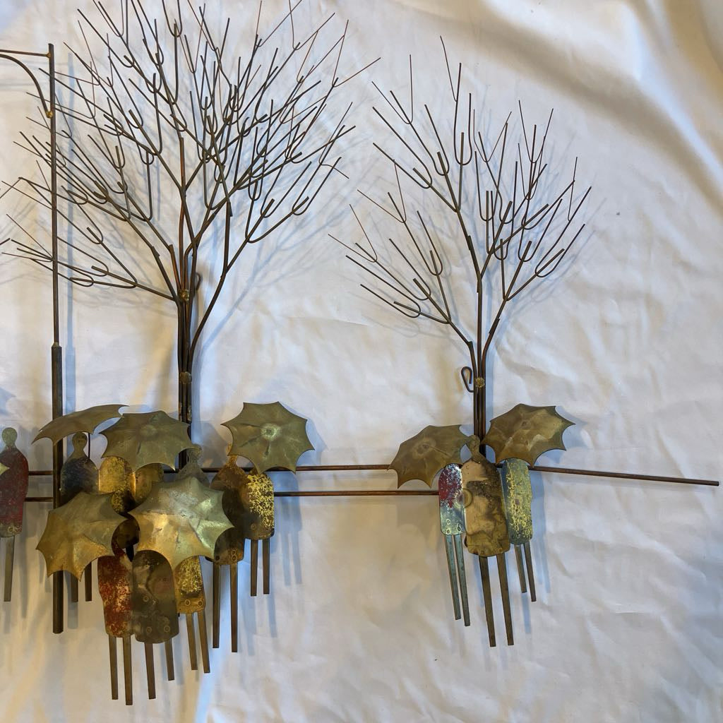 Decorative wall art with metal trees and human figures on a textured white background