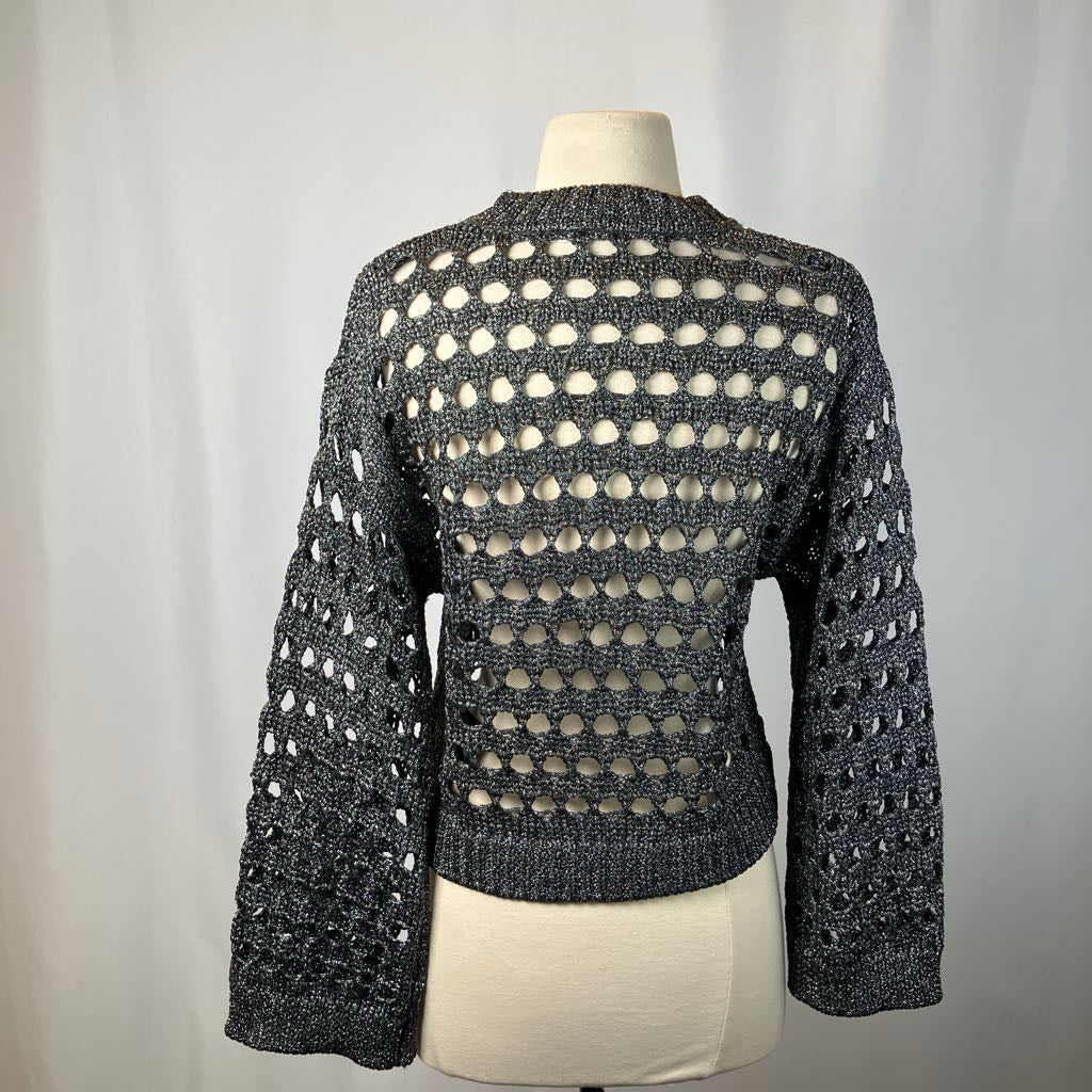 Mannequin wearing a black and white patterned sweater against a gray background