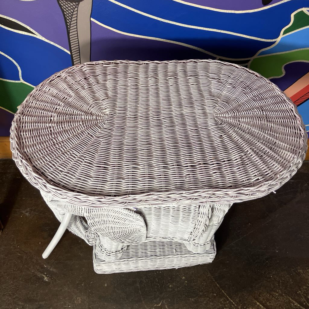 Wicker table with a colorful abstract painting in the background