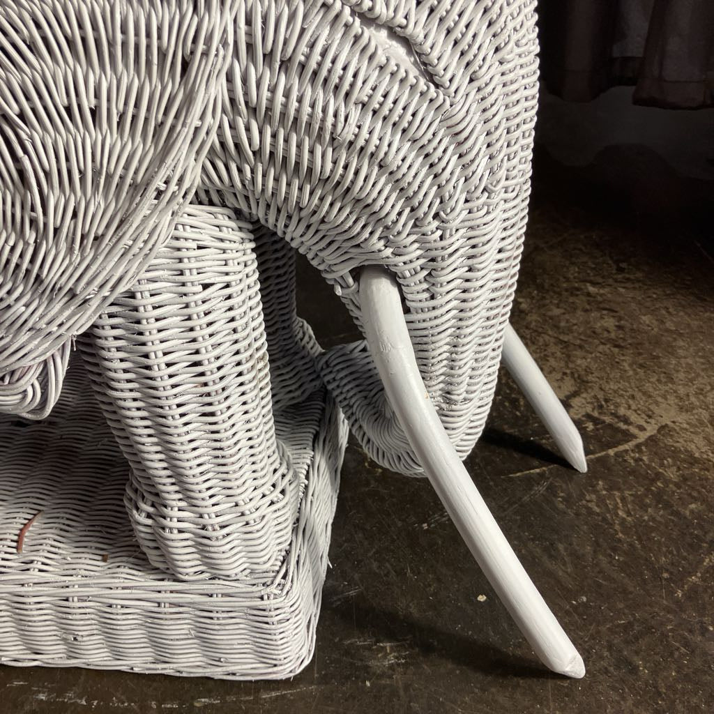 White woven elephant sculpture on a textured surface