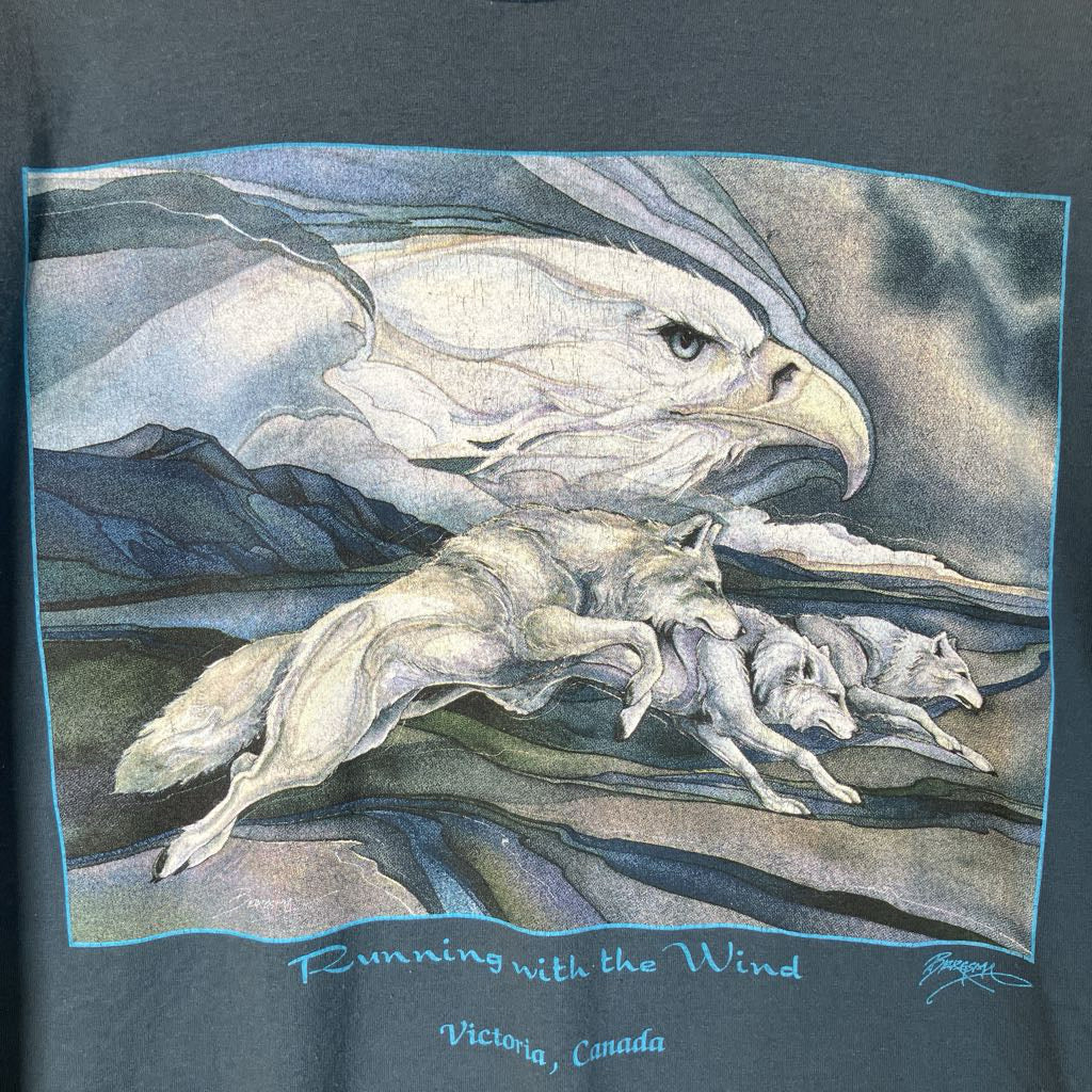 T-shirt with a graphic of an eagle and horse running, with text 'Running with the Wind Victoria, Canada' on a dark background.