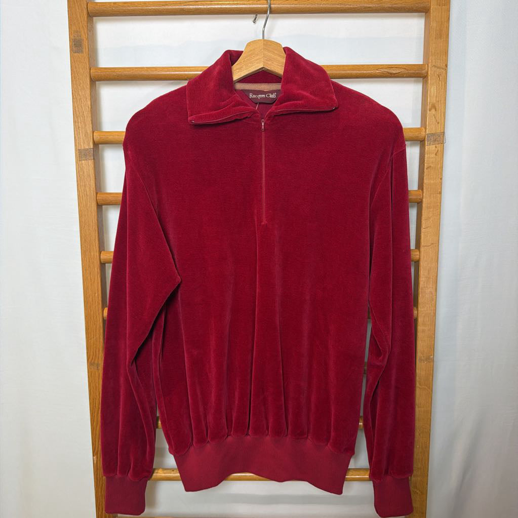 A red velour sweater on a wooden rack. 