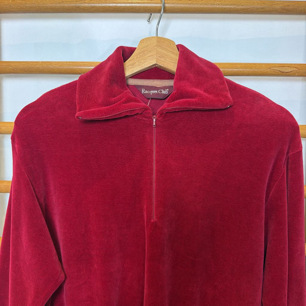 A red velour sweater on a wooden rack. 