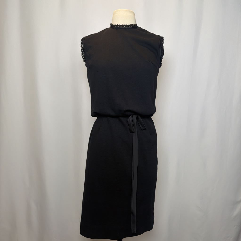 Black sleeveless dress on a mannequin against a plain background