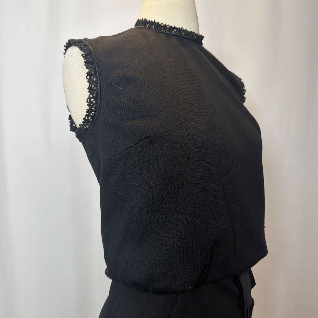 Black sleeveless top with lace trim on a mannequin against a white background