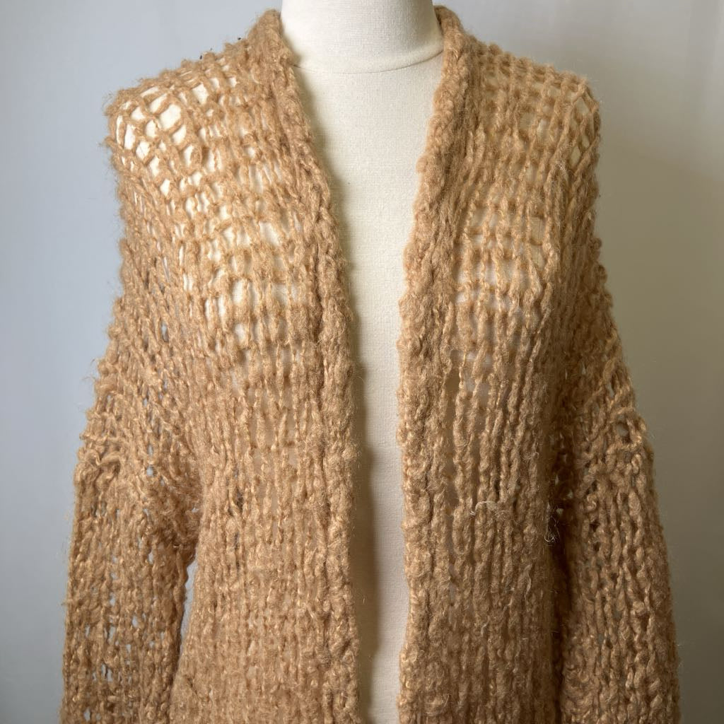 Brown knitted cardigan on a mannequin against a plain background