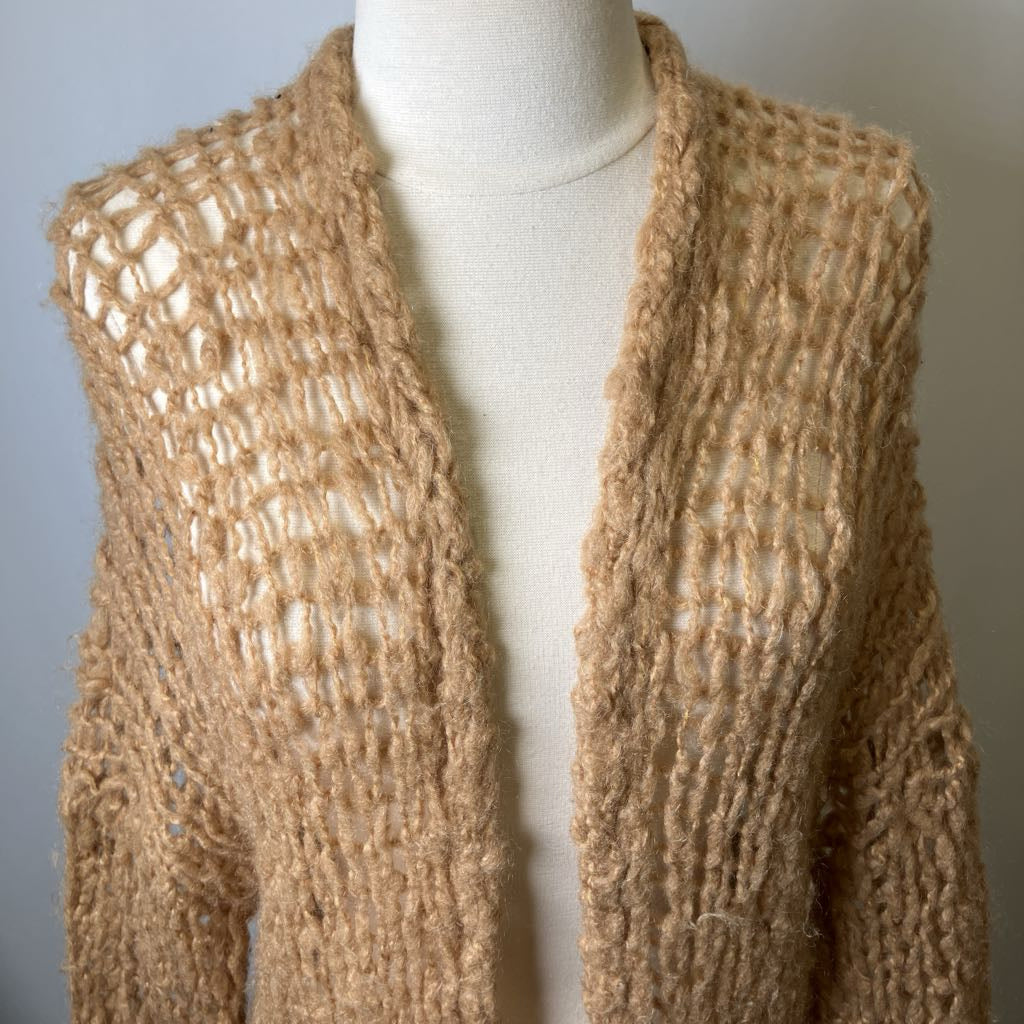 Beige knitted cardigan on a mannequin against a neutral background