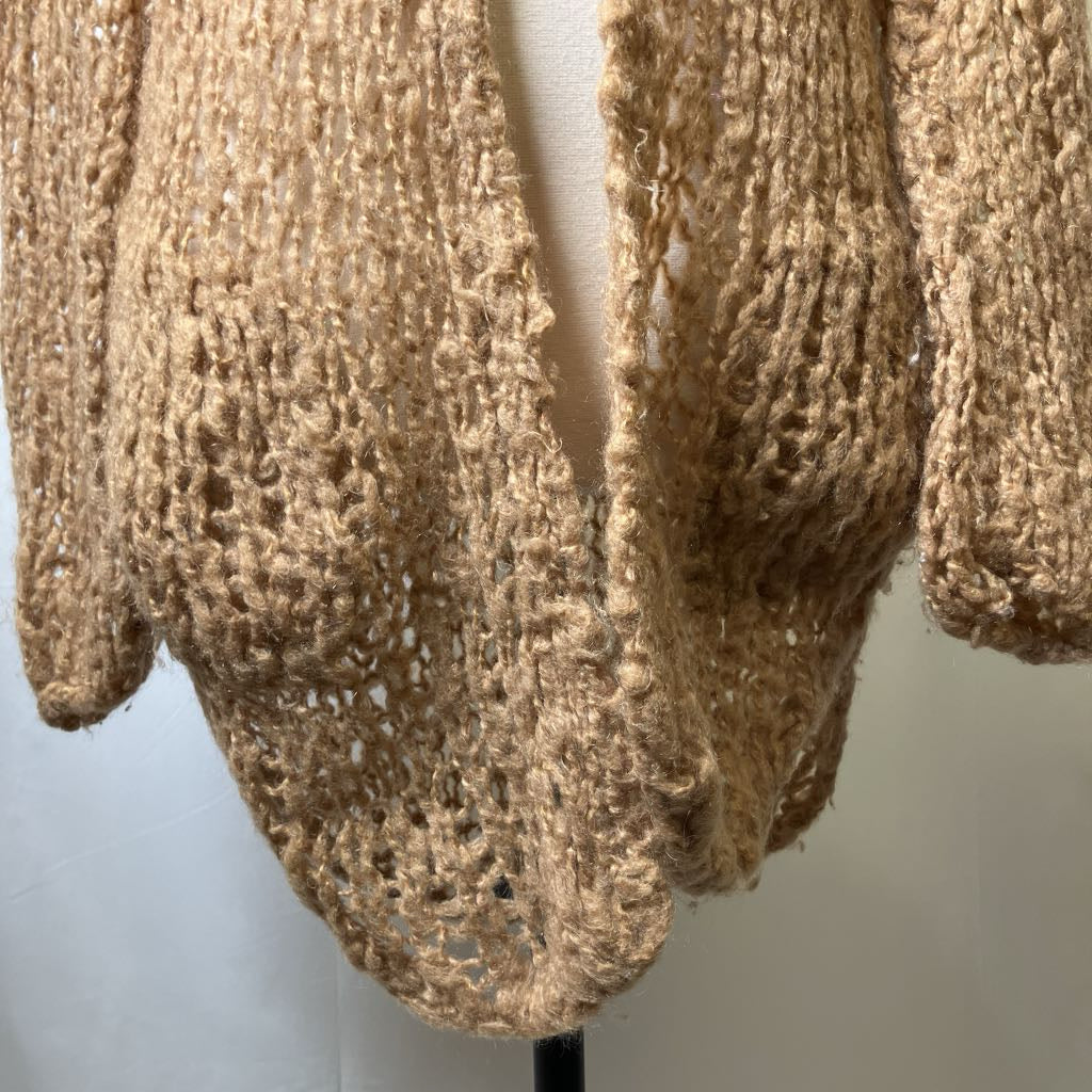 Knitted beige sweater on a mannequin against a plain background