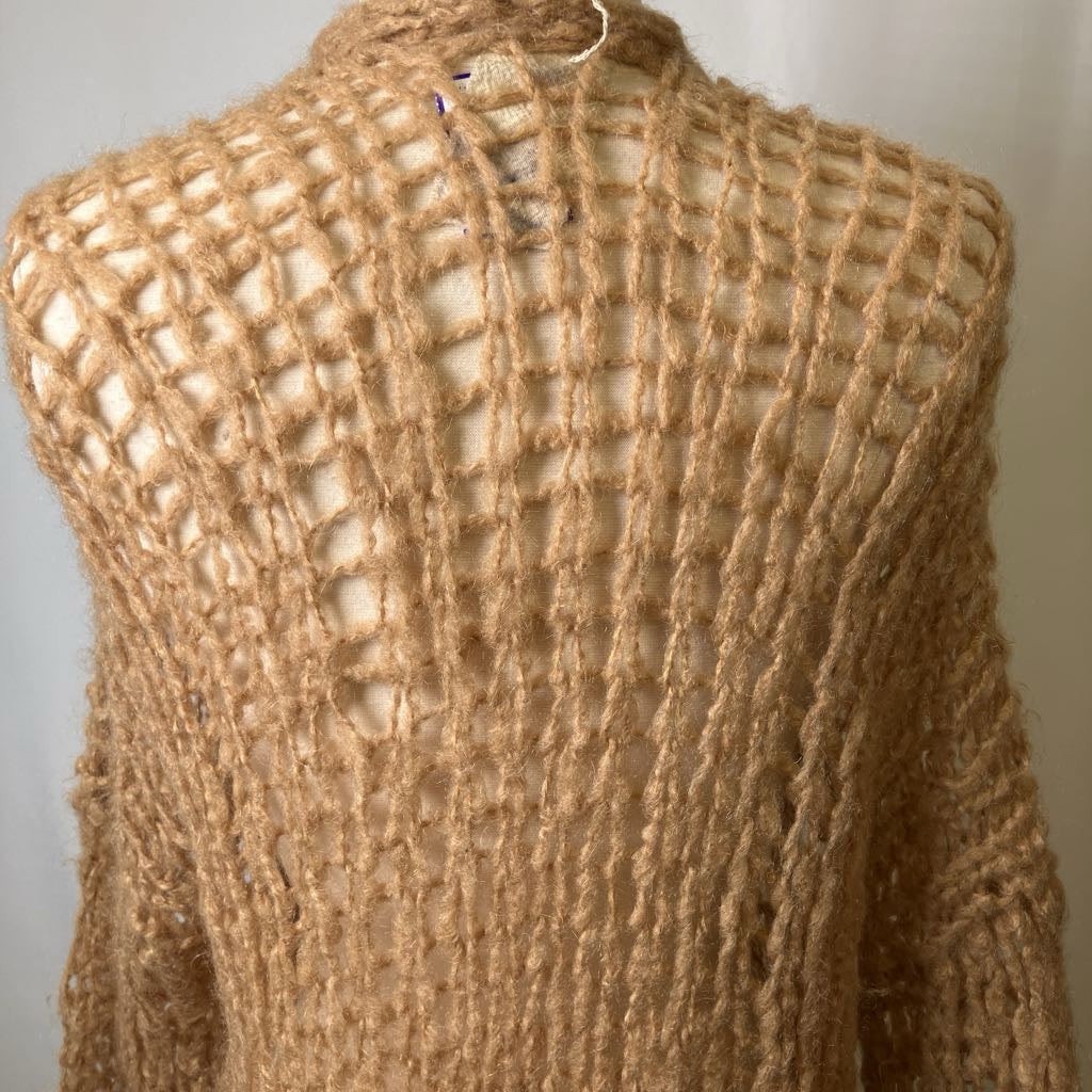Brown knitted sweater on a mannequin against a plain background