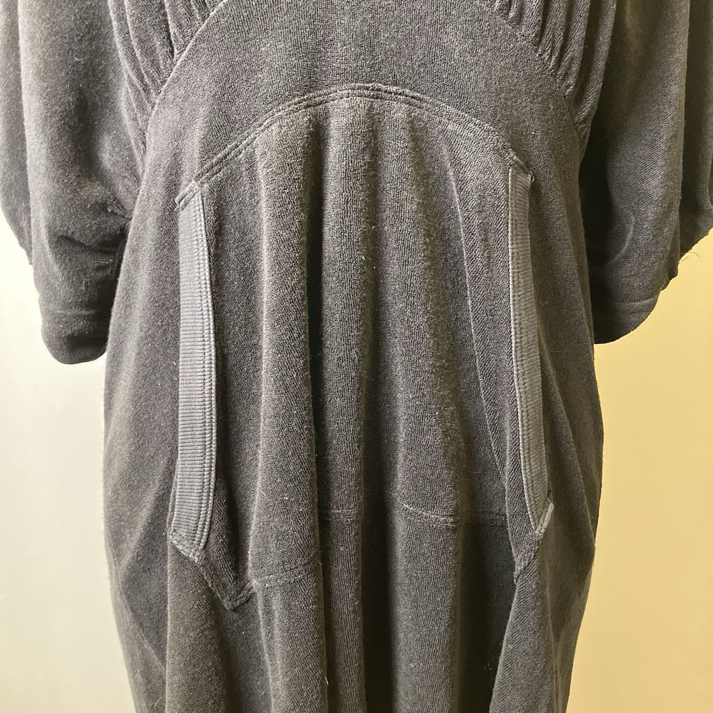 Black textured garment with pockets on a beige background