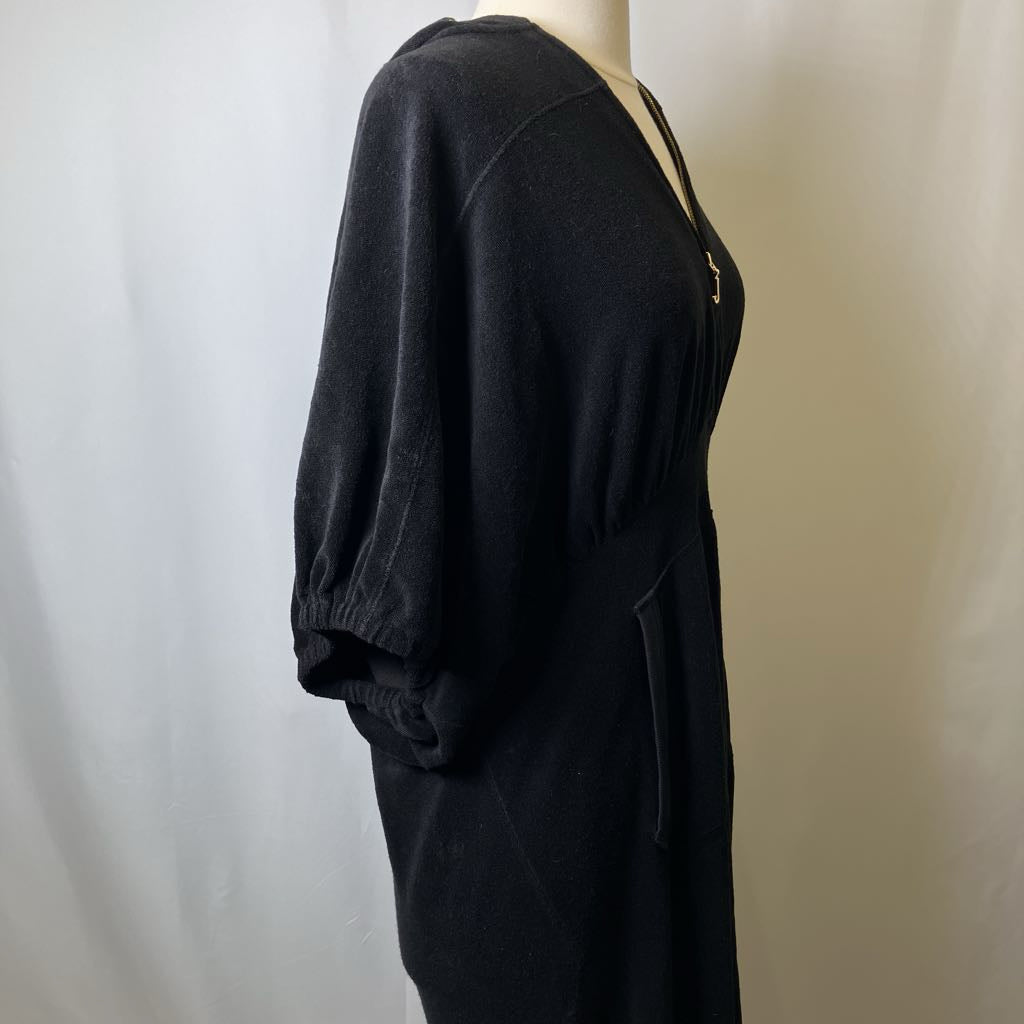 Black dress on a mannequin against a plain background