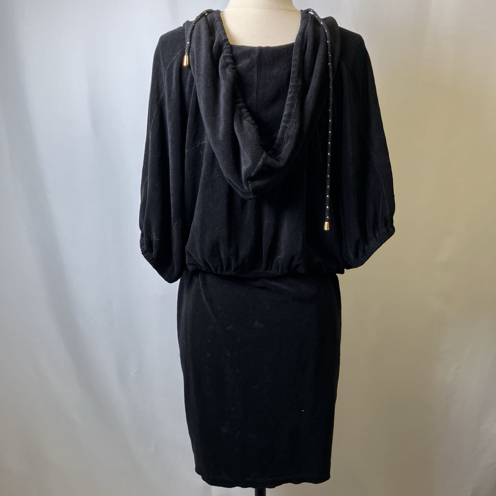 Black dress with a hood on a mannequin against a plain background