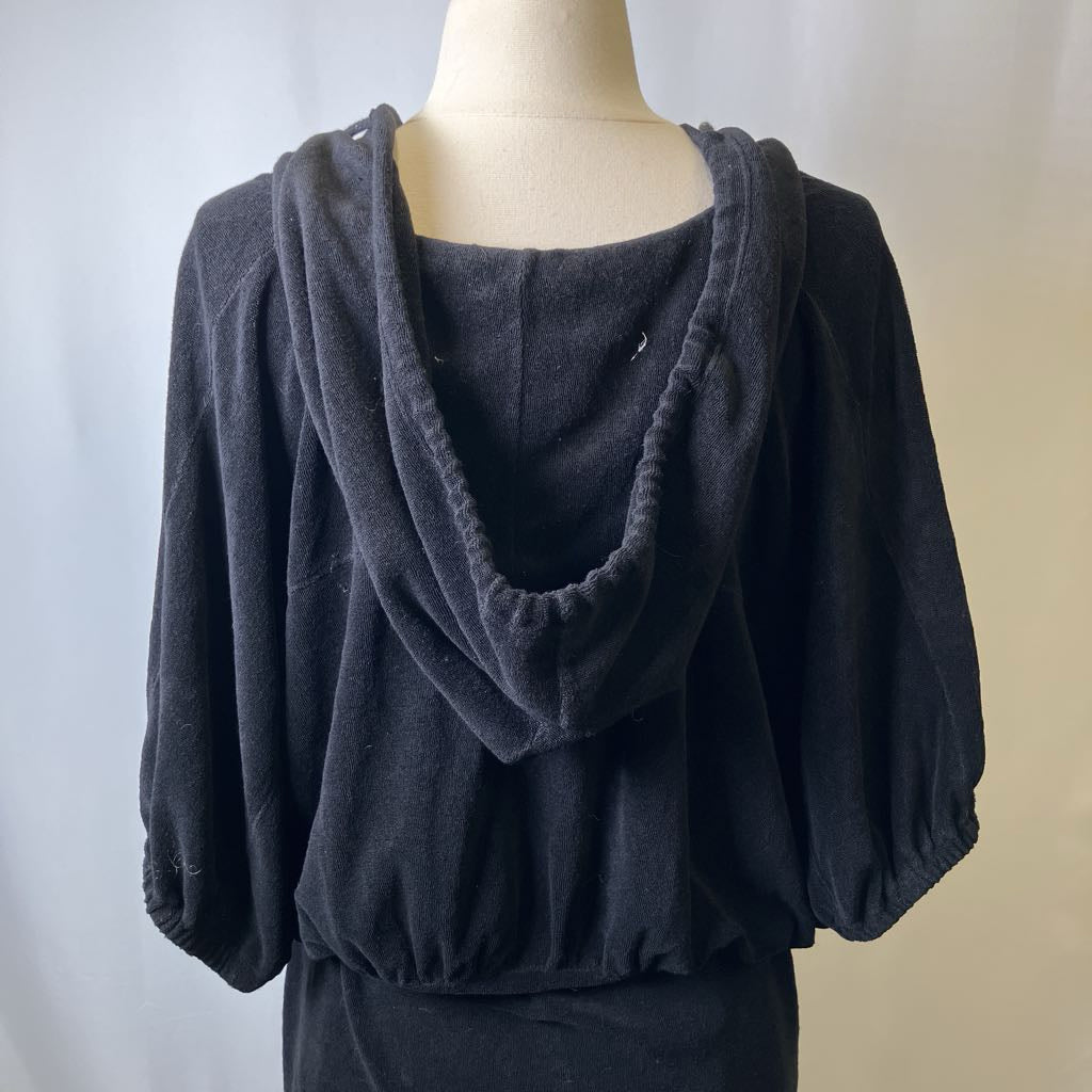 Black hooded garment on a mannequin against a neutral background