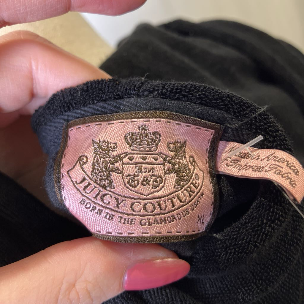 Close-up of a Juicy Couture label on black fabric.