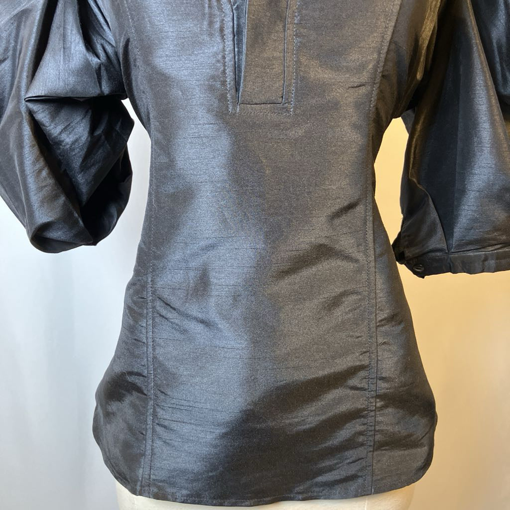 Dark black blouse on a mannequin with a plain background