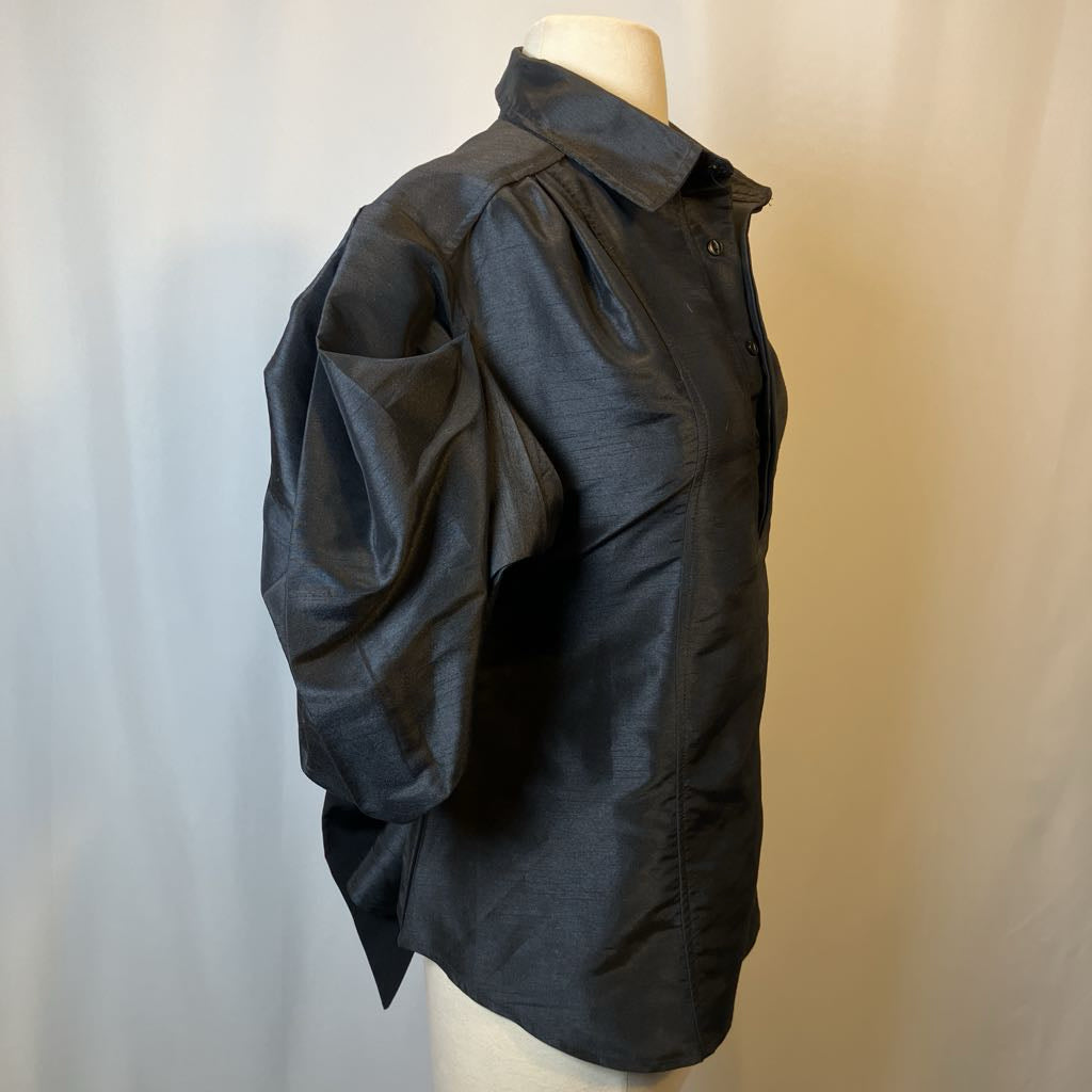 Black shirt on a mannequin against a plain background