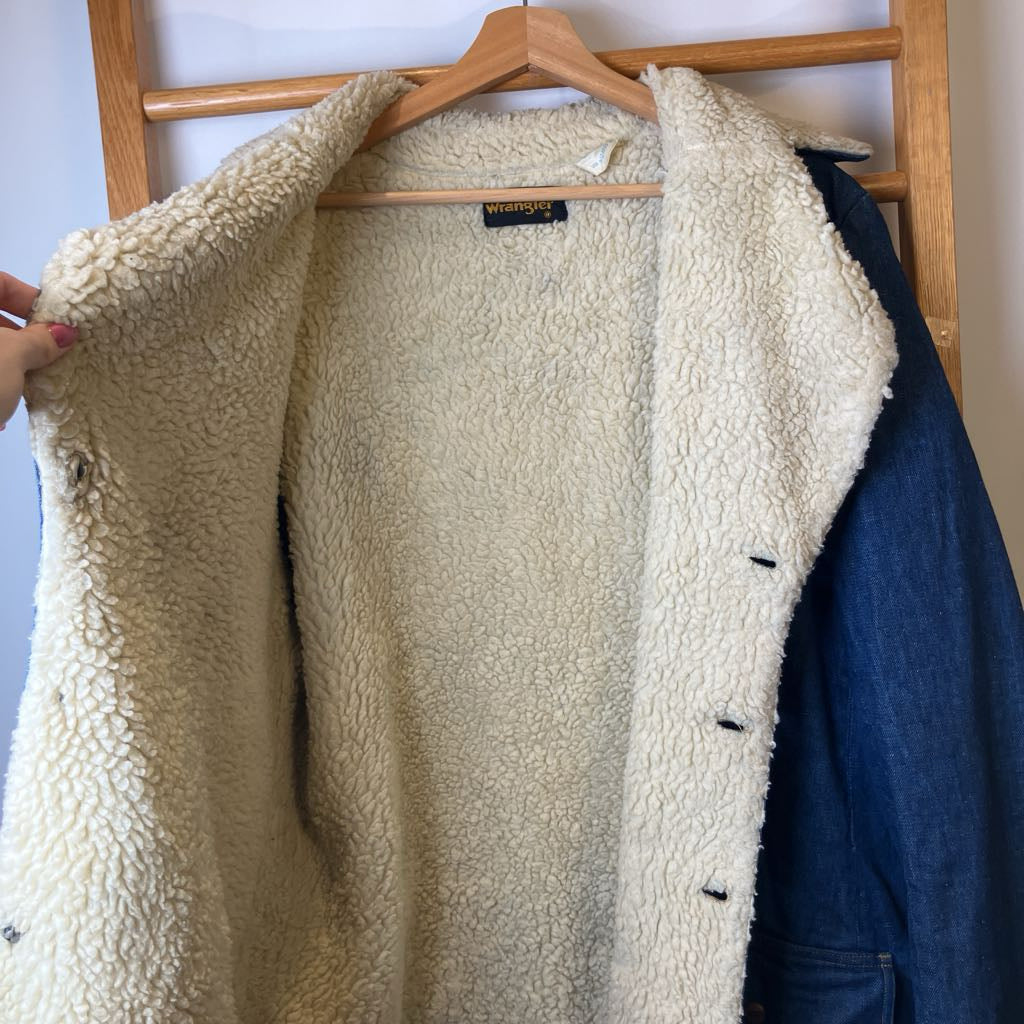 Beige fleece jacket on a hanger with a visible brand label.