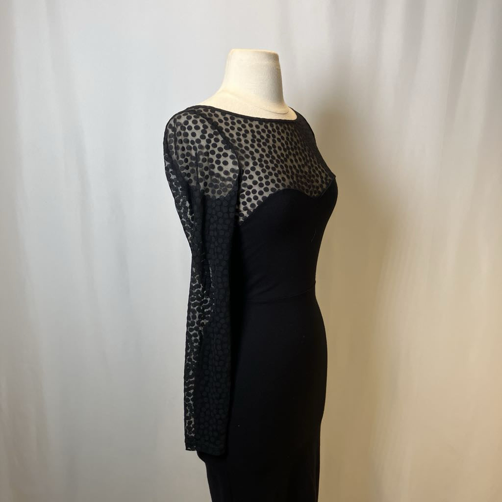 Black dress with sheer sleeves on a mannequin against a plain background