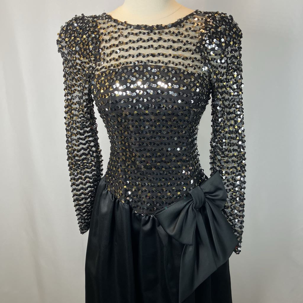 Black sequin dress with a large bow on a mannequin against a gray background