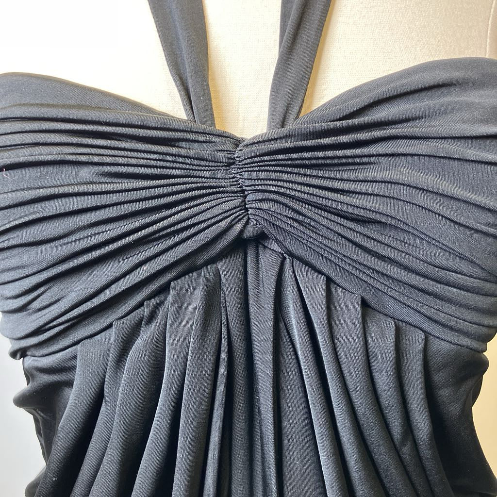 Black pleated dress with a large bow detail on a white background