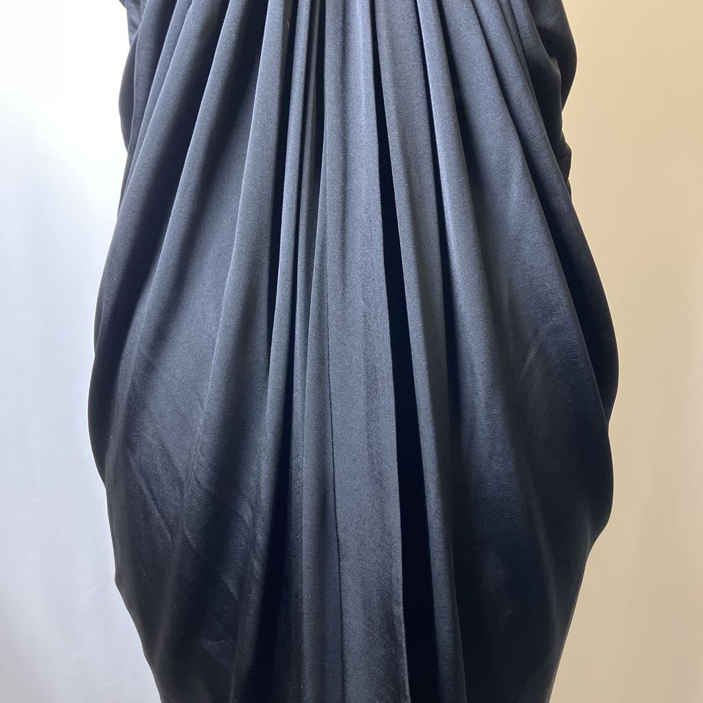 Black fabric draped over a mannequin against a neutral background