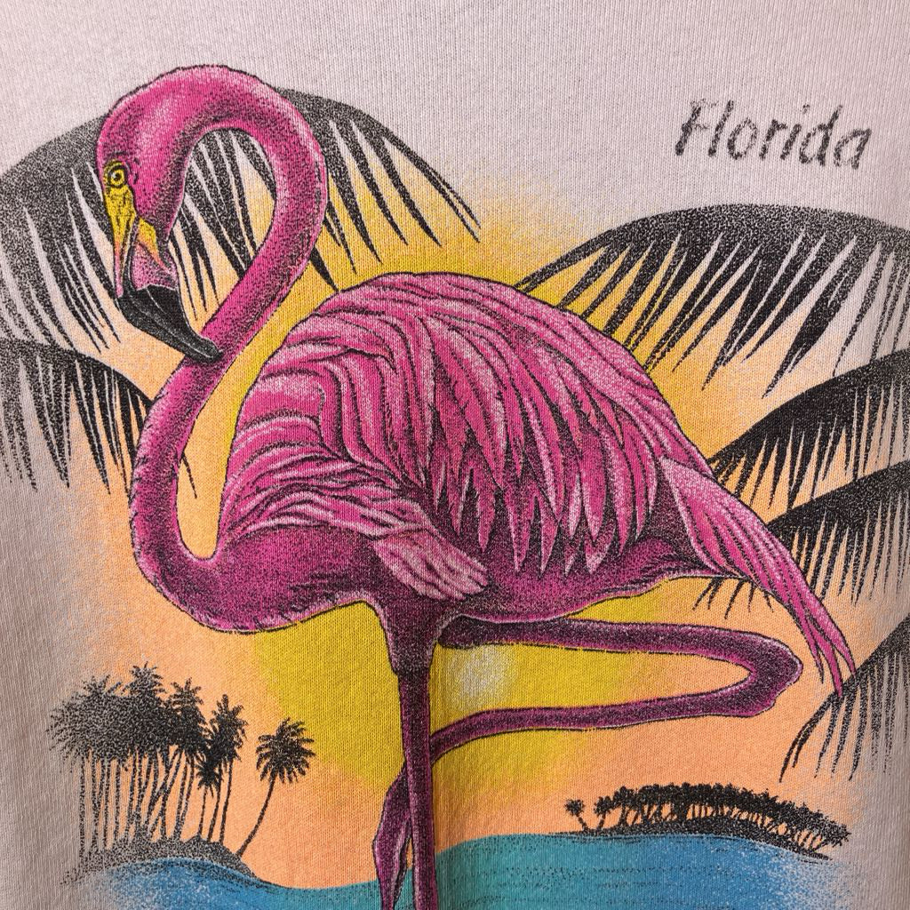 Flamingo illustration with palm trees and 'Florida' text on a shirt.