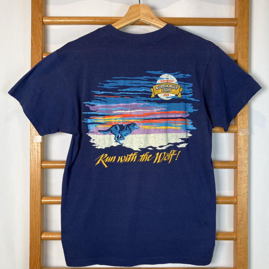 Navy blue t-shirt with graphic design and text on a wooden rack