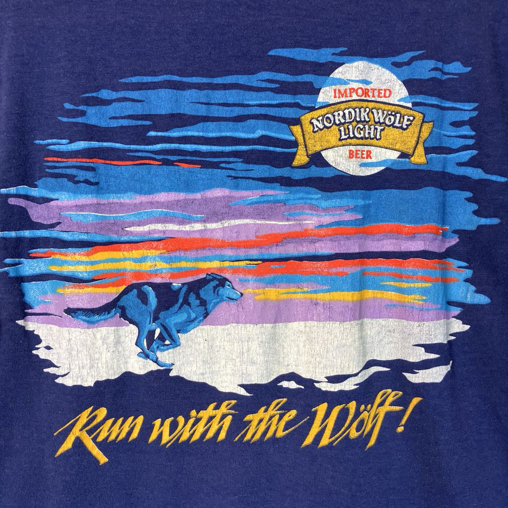 T-shirt with a wolf graphic and 'Imported Nordik Wolf Light Beer' logo on a blue background