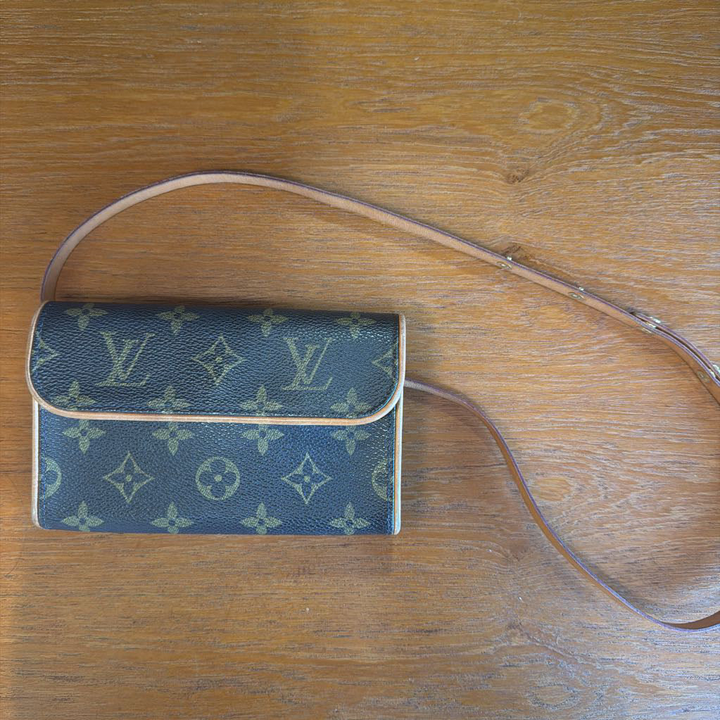 Blue monogram handbag with a strap on a wooden surface