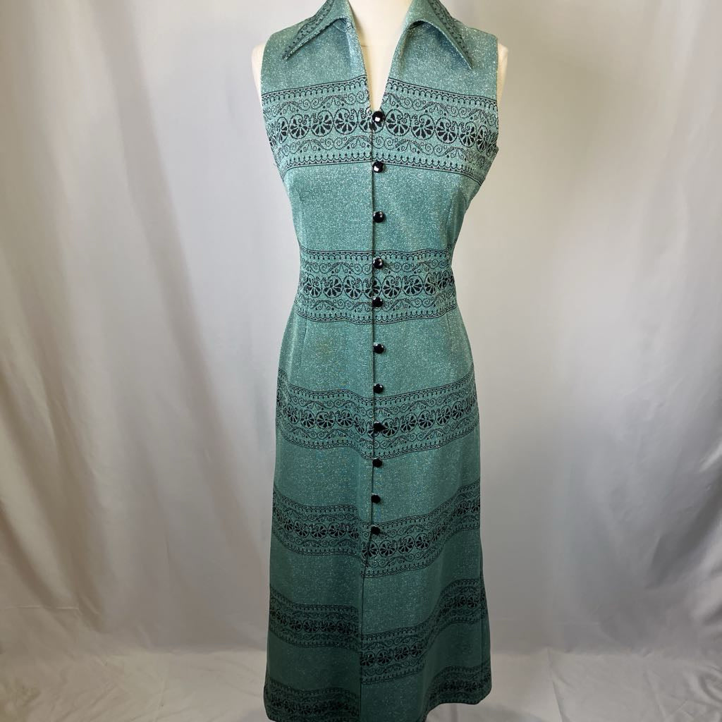 Green dress with black patterns on a mannequin against a white background