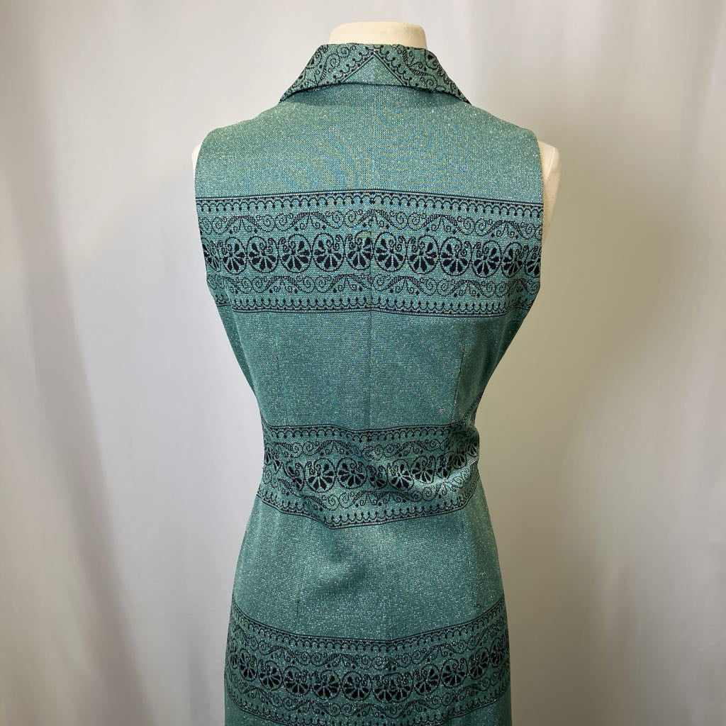Teal dress with intricate black lace detailing on a mannequin against a plain background